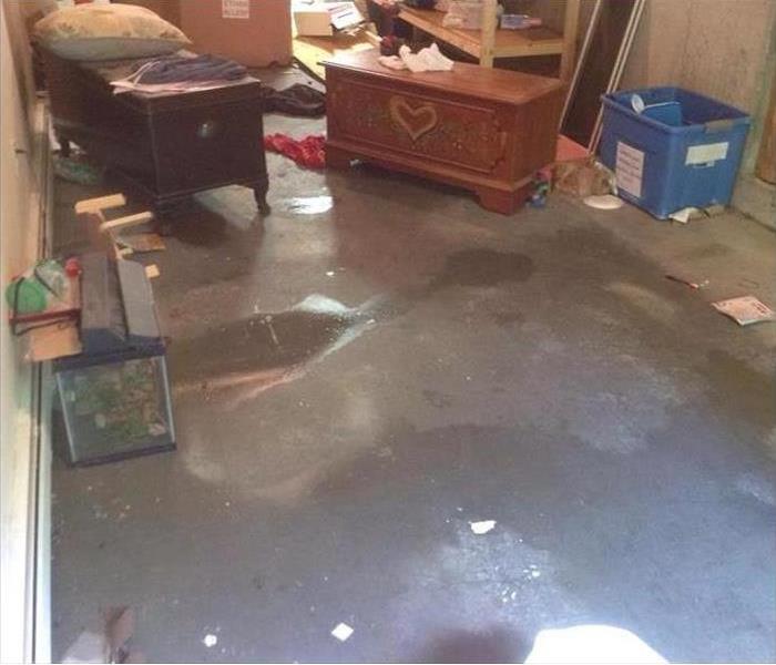 water on concrete floor in a basement, contents around