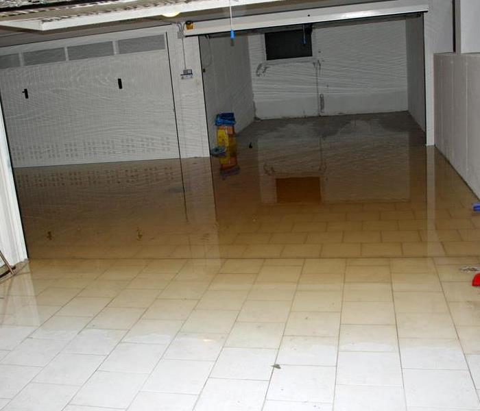 Standing water on a white tile floor.